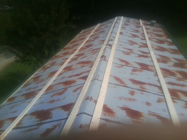 Rusted metal roof panels with new wood purlins before replacement — Storm Damage Roof Repair in Luzerne by Roofing Brothers
