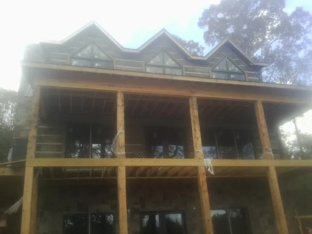 Dormers and porch framing on a large log home under construction in Luzerne