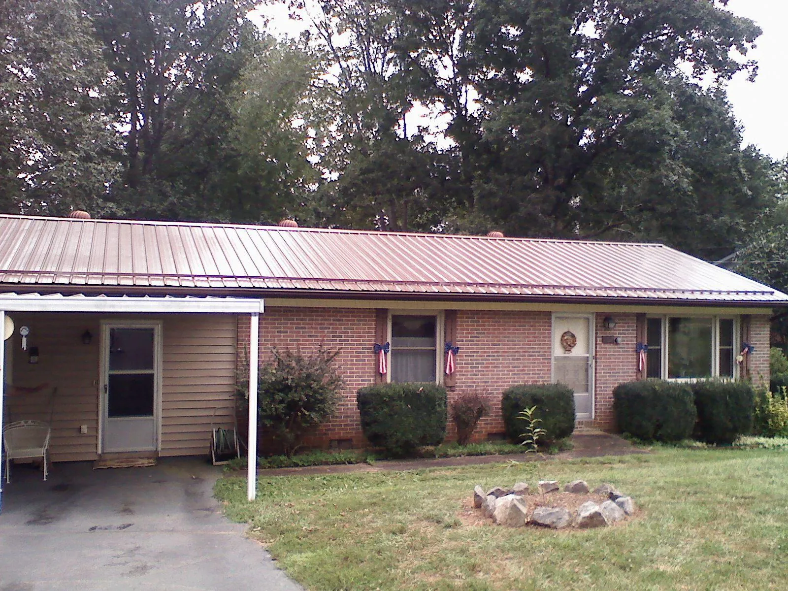 Bronze metal roof and carport on a brick ranch home — Roof Repair work by our crew in Luzerne